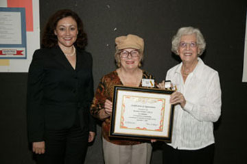 Board President Alexandria Coronado (left) presents the Outstanding Contributions to Education Award to Rossmoor Woman’s Club Pr
